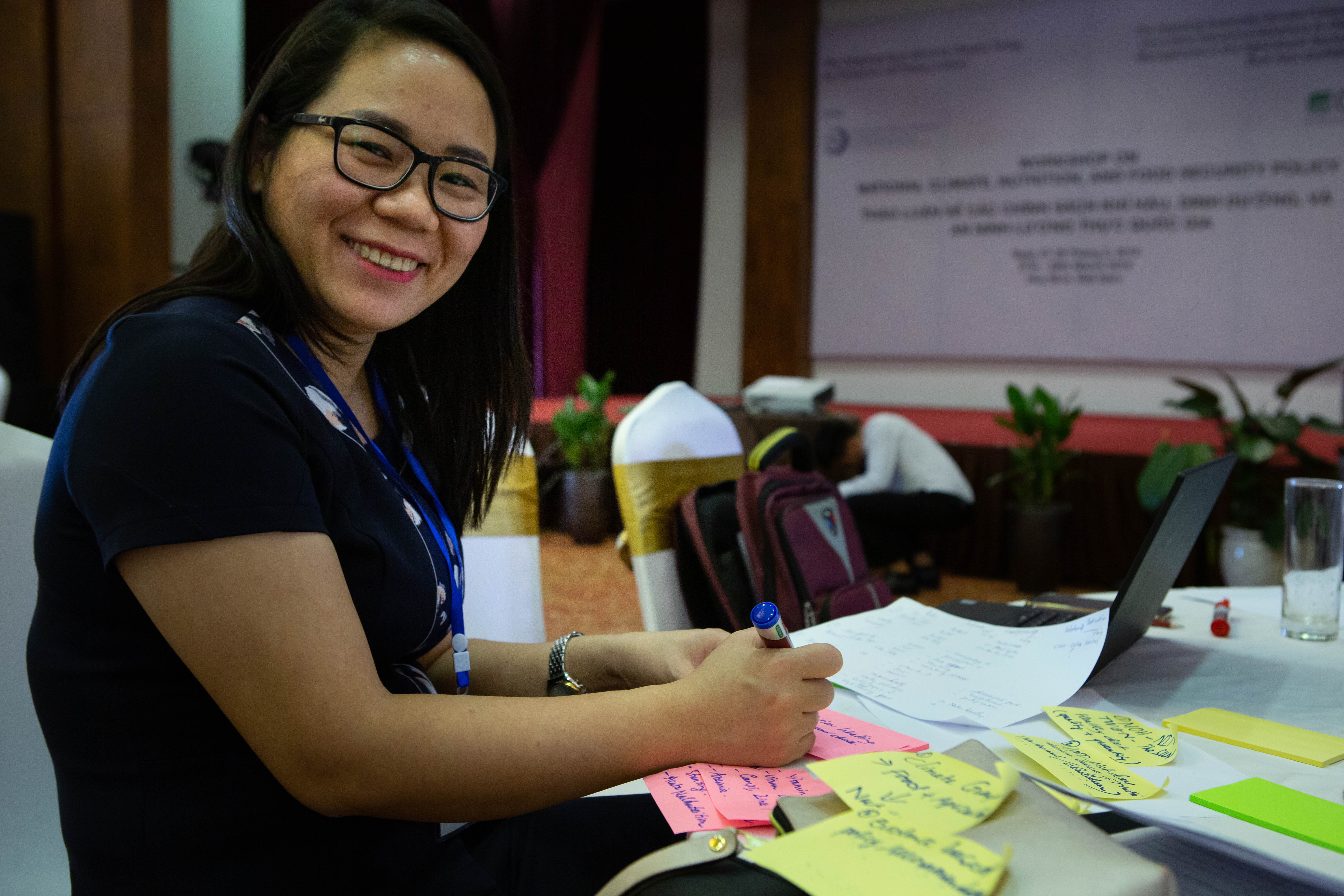 Dr. Truong Mai from the National Institute of Nutrition writes notes for a group activity where participants identified challenges to achieving their objectives for UN Sustainable Development Goal 2.